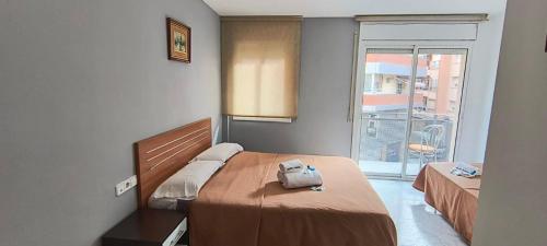 塔拉戈纳Hostal Europa的一间卧室设有两张床和大窗户