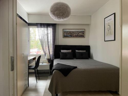 波尔沃Rauhallinen rivitalon pääty的一间卧室配有一张床、一张桌子和一个窗户。