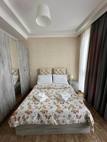 库塔伊西Rustaveli Apartment 113的一间卧室配有一张带花卉床罩的床