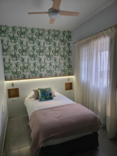 蒂约那Mi Rincon en La Pedrera的一间卧室配有一张带花卉墙壁的床