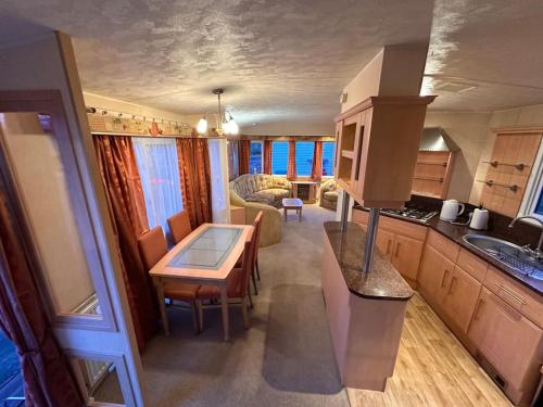 阿丁斯顿Atlas 2 Bedroom Caravan, Glasgow的一间厨房和客厅,客厅内配有桌子。