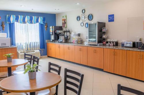 金斯兰Microtel Inn & Suites by Wyndham Kingsland Naval Base I-95的餐厅设有2张桌子和1个带厨房的柜台