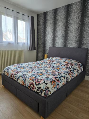 谢勒Maison Paris, Vallée Village, Disney & Astérix的一间卧室配有一张带五颜六色被子的床