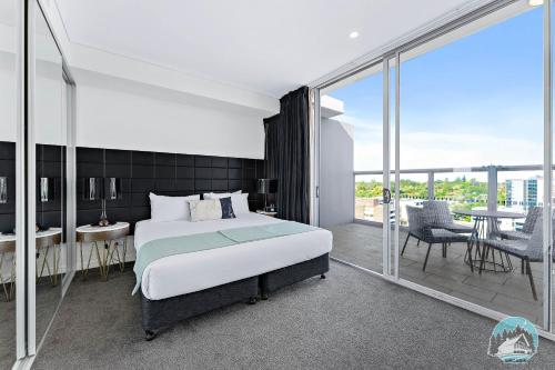 悉尼2 beds luxury apartment in the heart of chatswood12的一间带大床的卧室和一个阳台