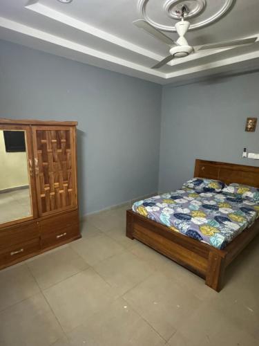 瓦加杜古Prestige House的一间卧室配有一张床和吊扇