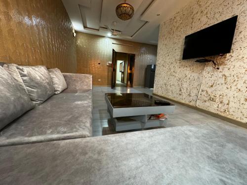 瓦加杜古Prestige House的客厅配有沙发和墙上的电视