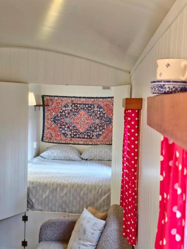拉纳肯pipowagen met prive Hot tub的一间小卧室,配有一张床和墙上的地毯