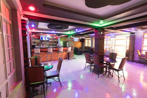 纳纽基Africa One Hotel的一间带桌椅的餐厅和一间酒吧