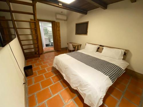 金沙镇煦乐轩古厝民宿的一间卧室配有一张带白色床单的大床