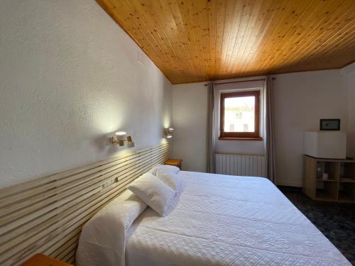 Vilanova de EscornalbouHotel Rural Cal Amadeu的卧室配有白色床和木制天花板