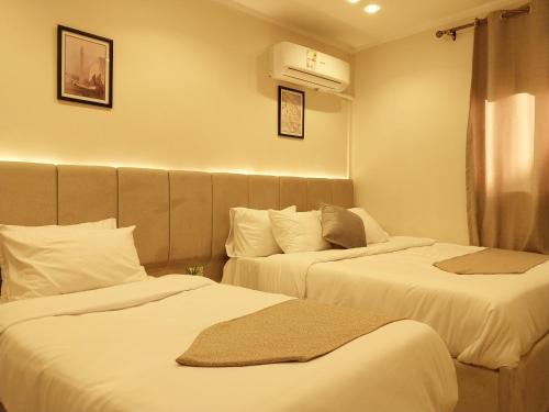开罗Casablanca Hotel的酒店客房,配有两张带白色床单的床