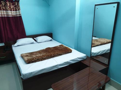德奥加尔Hotel Ambika的镜子前床边的棕色毯子