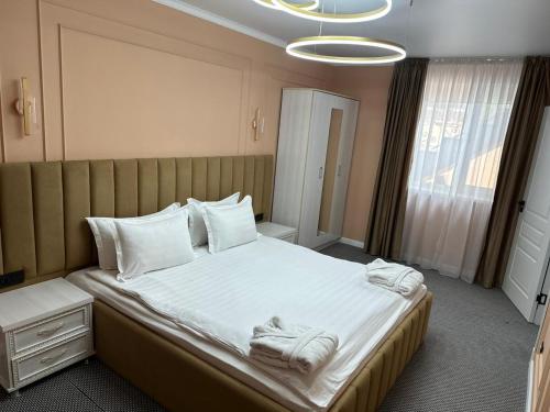 塔拉兹Вояж的一间卧室配有一张大床和毛巾