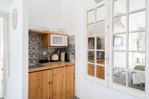 科英布拉CoimbraAmeias的厨房配有木制橱柜和窗户。