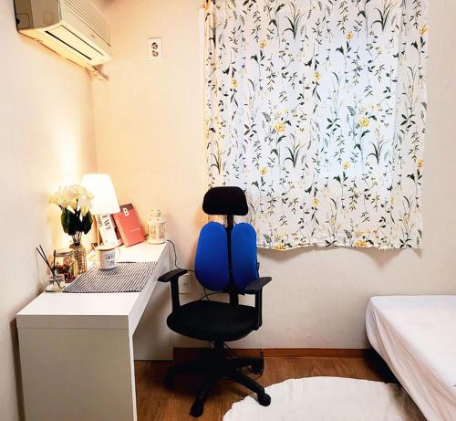 首尔NineRoD - Private bathroom & Shower的一张桌子和一把椅子,放在带窗帘的房间