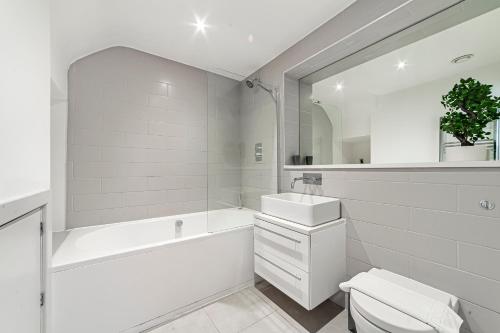 伦敦The Old Street Luxury Flat的白色的浴室设有浴缸、盥洗盆和卫生间。