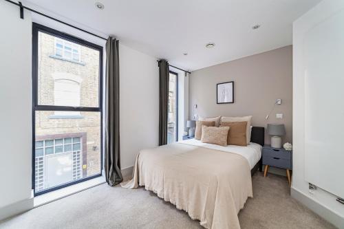 伦敦The Old Street Luxury Flat的一间卧室设有一张床和一个大窗户