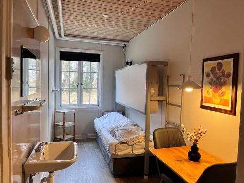 伦讷Rønne Vandrerhjem的小房间设有双层床和书桌