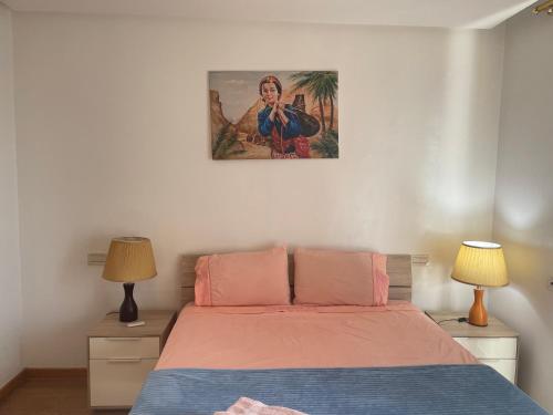 卡萨布兰卡Appartement Casa-marina au 10ème étage的卧室配有一张床,墙上挂着一幅画