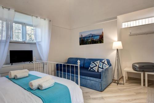 皮雅诺迪索伦托Il giardino di aranci e limoni的一间卧室配有一张床和一张蓝色的沙发