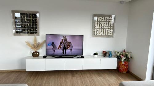 布兰肯贝赫Luxury Escape的客厅配有白色橱柜上的平面电视