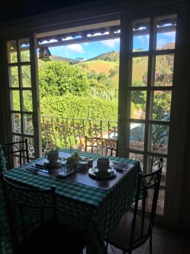 康赛瓦托利亚Pousada Talho da Serra的一张桌子,透过窗户可欣赏到葡萄园的景色