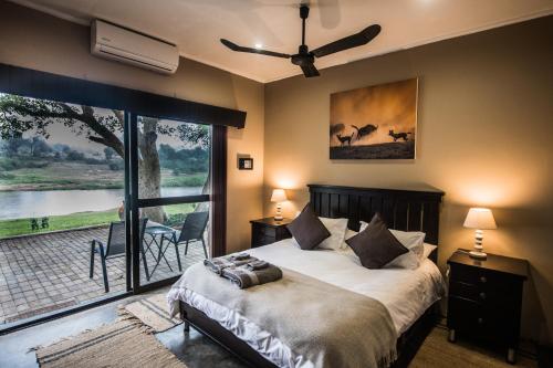 巴卢莱自然保护区Maninghi Lodge的一间卧室设有一张床和一个大窗户