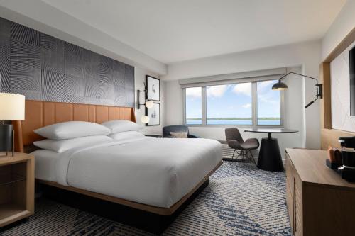 伊利Sheraton Erie Bayfront Hotel的酒店客房设有一张大床和一张桌子。