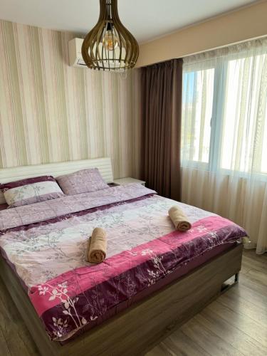扬博尔Апарт Диана的一间卧室配有一张带粉红色棉被的大床