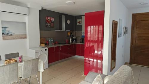 特尔德Casa Alisios的一间厨房,配有红色橱柜和红色门
