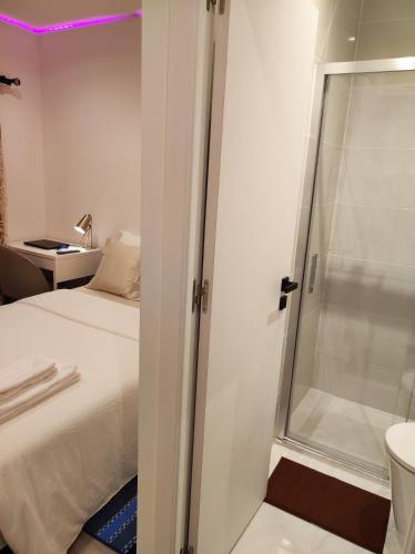 阿马多拉Vista Panorâmica RC Amadora的卧室设有淋浴,位于床边