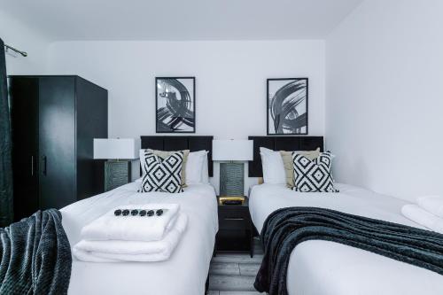 圣海伦斯New 2 Bed House - Perfect for Contractors & Families By AV Stays Short Lets St Helens的两张带白色床单和枕头的床。