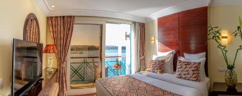 卢克索Sonesta Moon Goddess Cruise Ship From Luxor to Aswan - 04 & 07 nights Every Monday的一间卧室设有一张床和一个大窗户