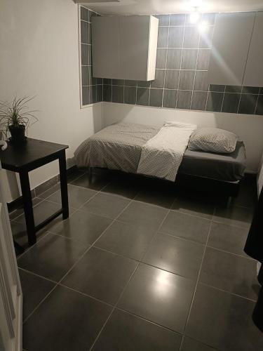德朗西Tiny house - Gare Paris Aeroport的卧室配有一张床和一张桌子