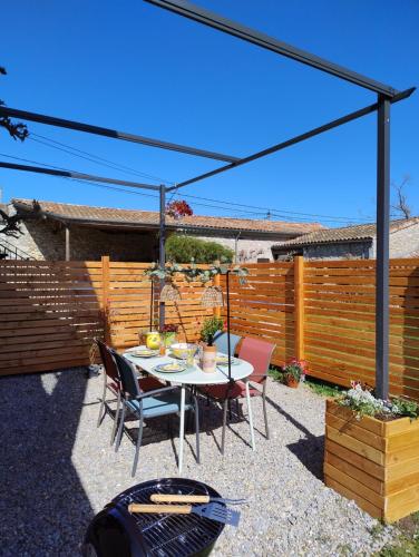 瓦隆蓬达克Gites l’Olivier avec piscine的一个带桌椅和围栏的庭院