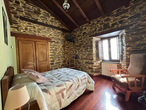 圣埃乌拉利亚德奥斯科斯Casa Freixe Apartamentos Rurales的一间卧室设有一张床和石墙