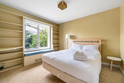 温哥华Tranquil Haven near Attractions: 4 BD Suite的卧室配有白色的床和窗户