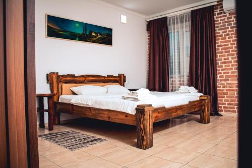 乌曼岛富埃特斯亚酒店的一间卧室配有一张带白色床单的木床