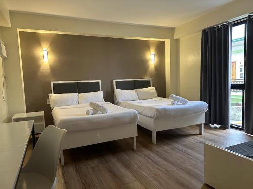 拉瓦格D'ELEMENTS HOTEL AND DORMITORY的酒店客房设有两张床和窗户。