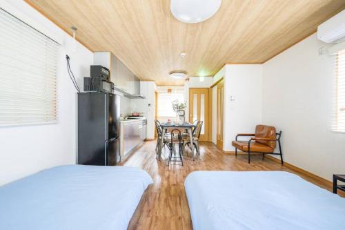 东京Premier suite Yoyogi front detached house的配有两张床、厨房和一张桌子的房间