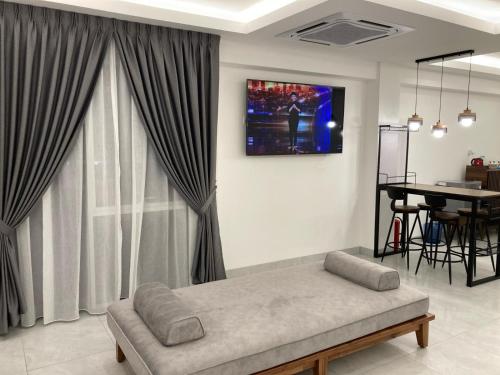 瓜拉比拉CS Junction Point - Family Deluxe Room FDR的客厅配有沙发和墙上的电视