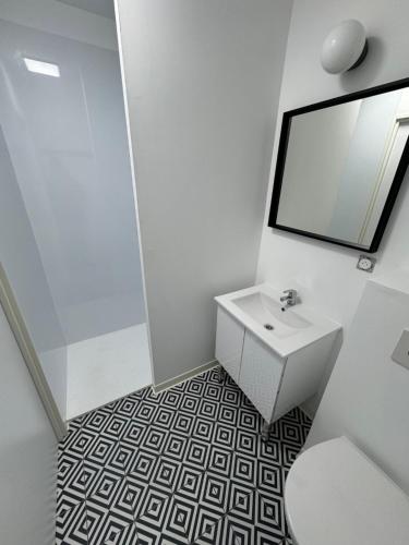 博瓦Apparthôtel Mont Saint Michel - Résidence Fleurdumont的白色的浴室设有水槽和镜子