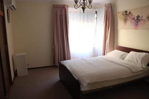 珀斯Comfort and Convenient的一间卧室设有一张大床和窗户