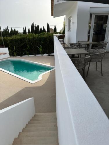 卢斯Casa Malìa Luxury Guest House的通往房子旁边的游泳池的楼梯