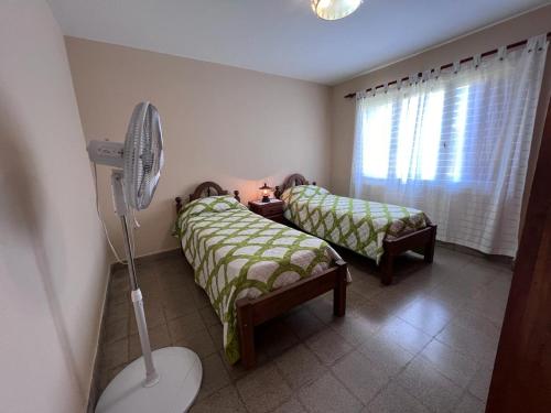 圣萨尔瓦多德朱Casa Felisa的一间带两张床和风扇的小卧室