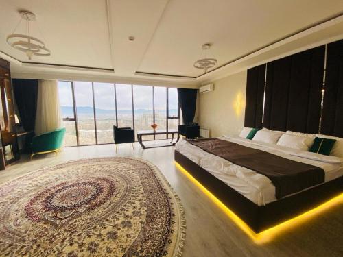 杜尚别BALAND HOTEL DUSHANBE的一间卧室配有一张大床和一张大地毯。