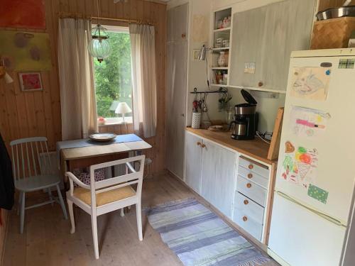 特鲁萨Lättillgängligt och trevligt hus的一间带桌子和冰箱的小厨房