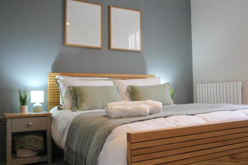 切尔滕纳姆New, Luxury Apartment in Town Centre的卧室配有一张大床,墙上挂有两张照片