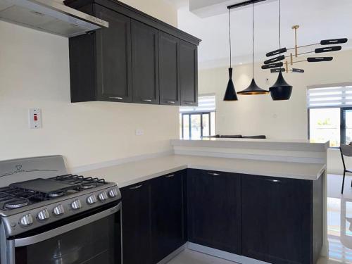 欧丘里欧Amore Villas的厨房配有黑色橱柜和炉灶。