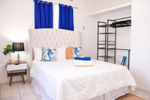 斯卡伯勒The ARC的一间卧室配有白色的床和蓝色窗帘